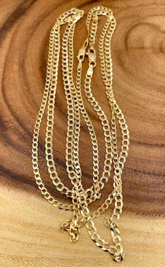 Gold chain necklace on a wooden surface