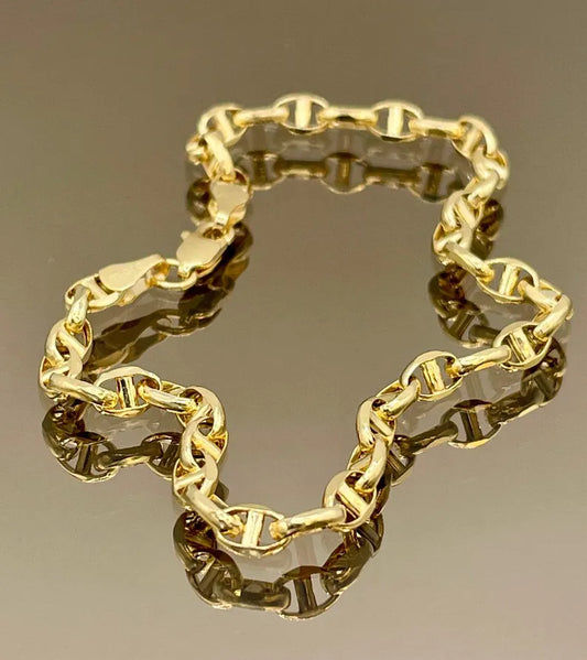 Gold chain bracelet on a reflective surface