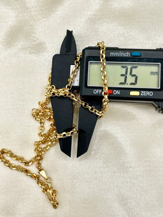 Gold chain being measured with a digital caliper on a light background