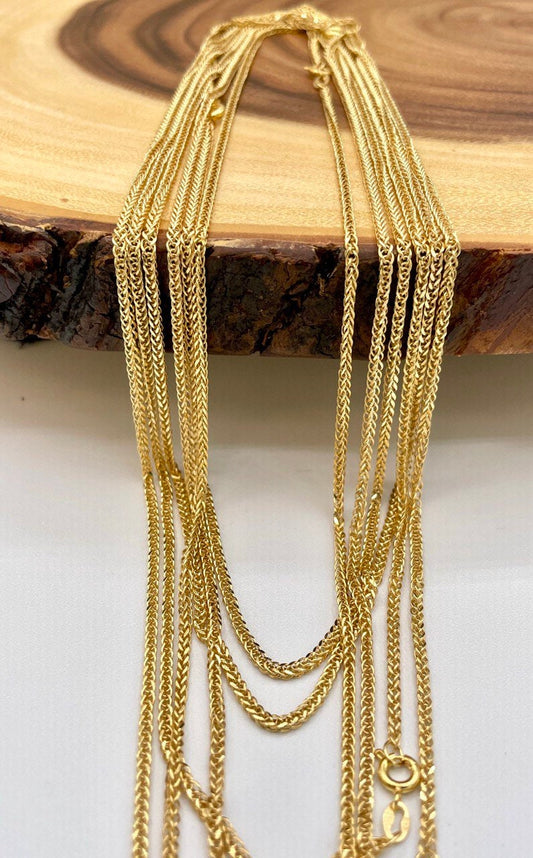 Gold chains displayed on a wooden surface