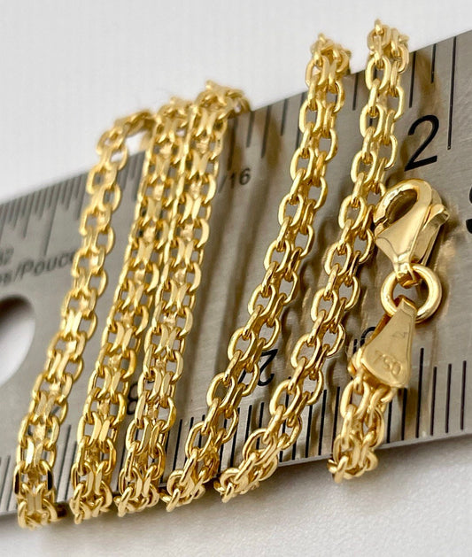 Gold chain necklace with clasp on a ruler for scale