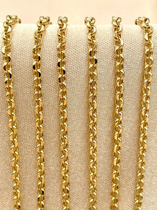 Set of gold chains displayed on a beige fabric background