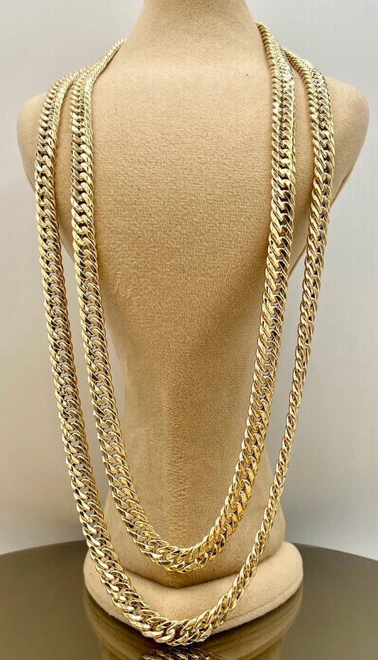 Gold chain necklace on a mannequin bust against a plain background