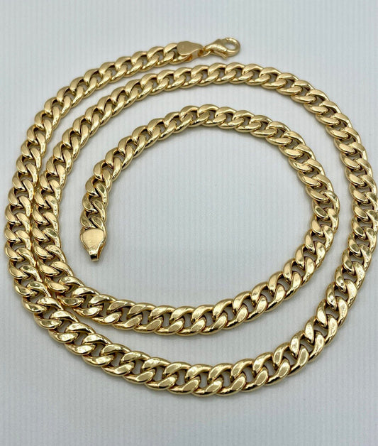 Gold chain necklace on a light gray background