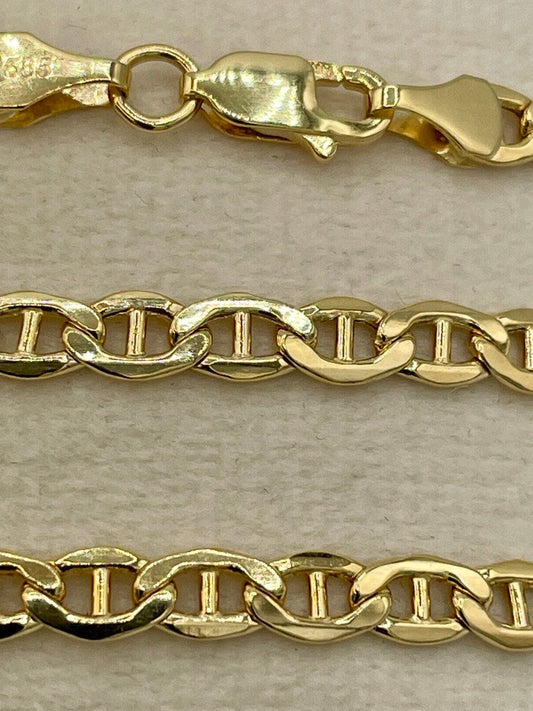 Gold chain necklace on a beige background