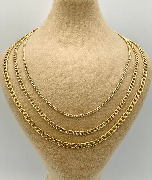 Three gold chains displayed on a mannequin bust against a plain background