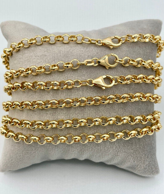Gold chains displayed on a gray pillow with a white background