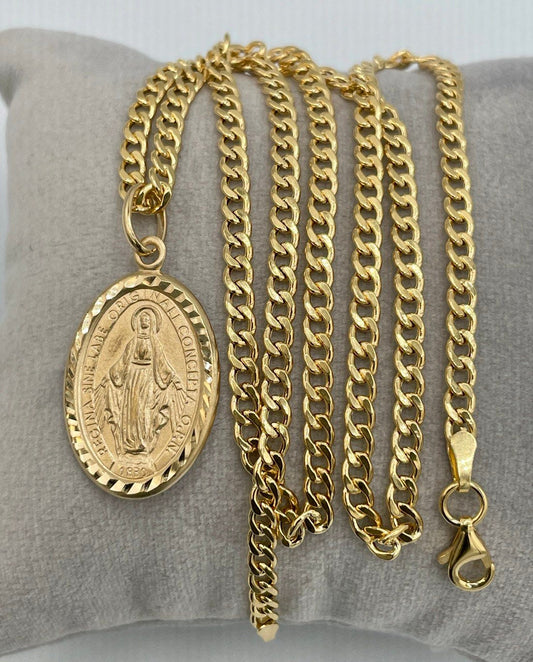 Gold chain necklace with a pendant on a gray cushion