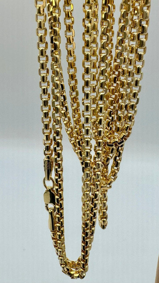 Gold chain necklace on a light gray background