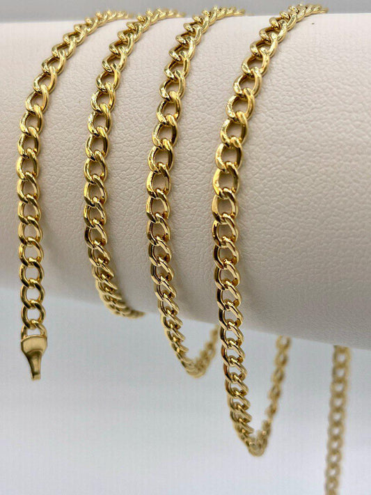 Gold chain necklaces displayed on a white surface