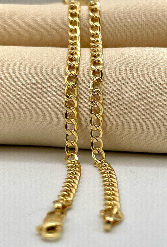 Two gold chains on a beige fabric background