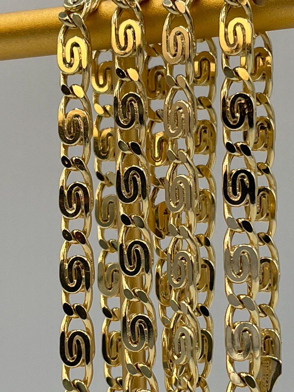 Gold chain with intricate design on a gray background