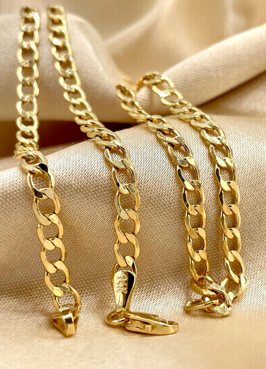 Gold chain necklace on a beige fabric background