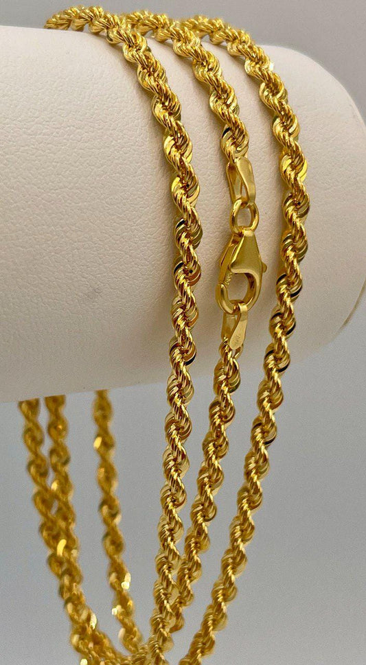 Three gold rope chains on a white surface