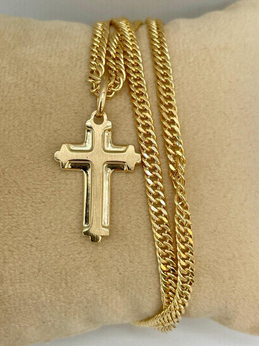 Gold chain necklace with a cross pendant on a beige cushion
