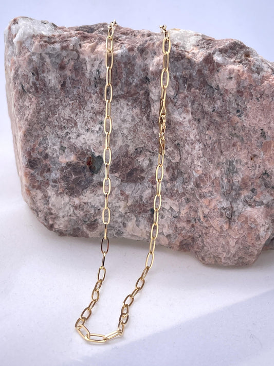 Gold chain necklace on a rock