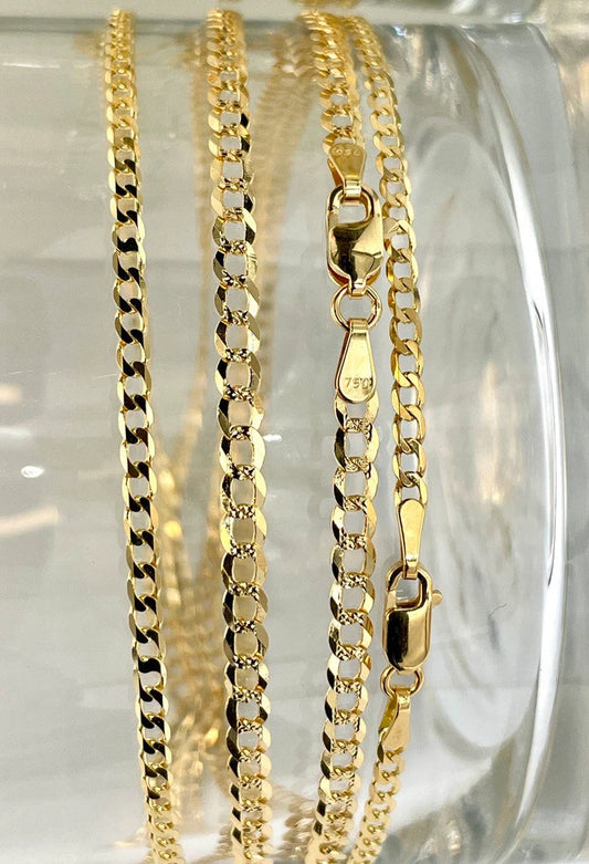 Three gold chains of different designs on a clear glass surface