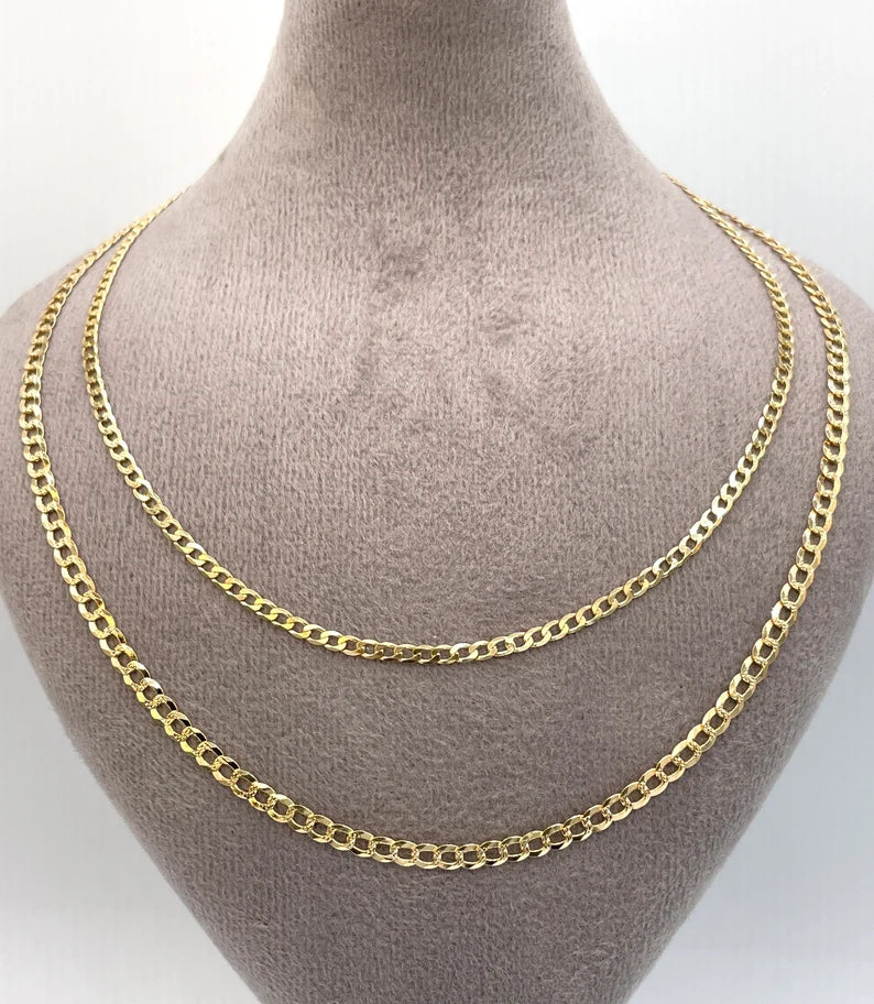 Gold chain necklace on a mannequin bust against a white background