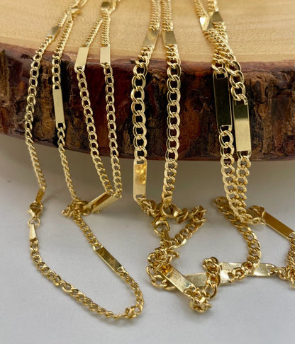 Gold chains displayed on a wooden block with a neutral background