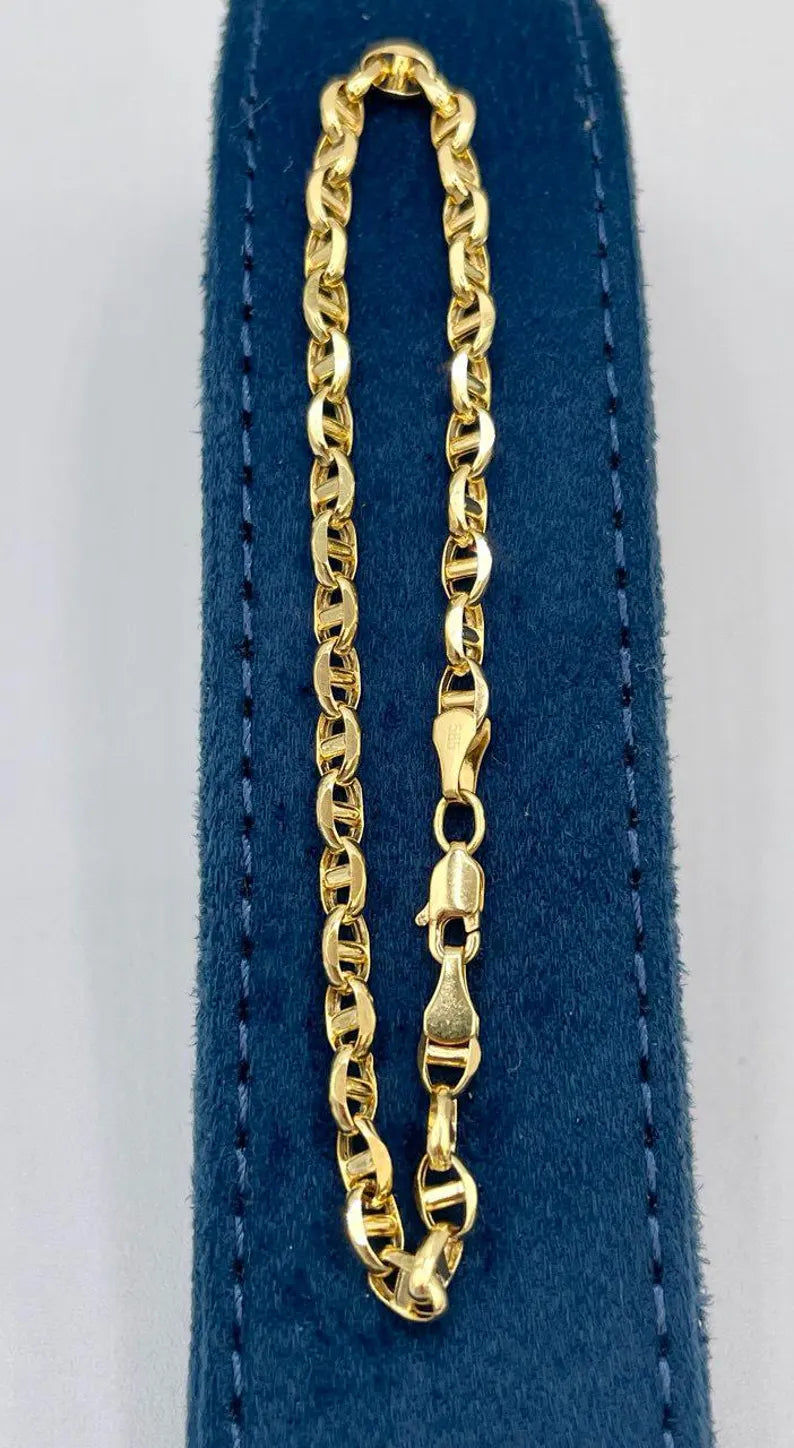 Gold chain necklace on a blue cushion