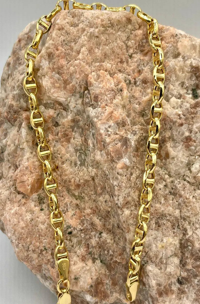 Gold chain on a textured stone surface
