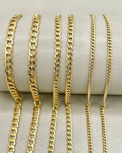 Set of gold chain necklaces on a white surface