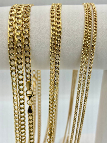 Gold chains displayed on a white stand