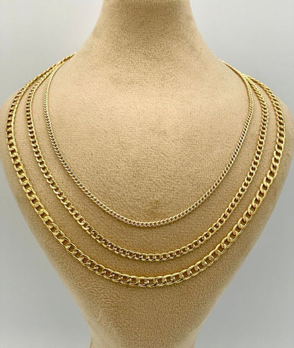 Three gold chains displayed on a mannequin bust against a plain background