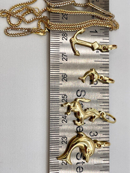 Gold pendants on a ruler for size reference