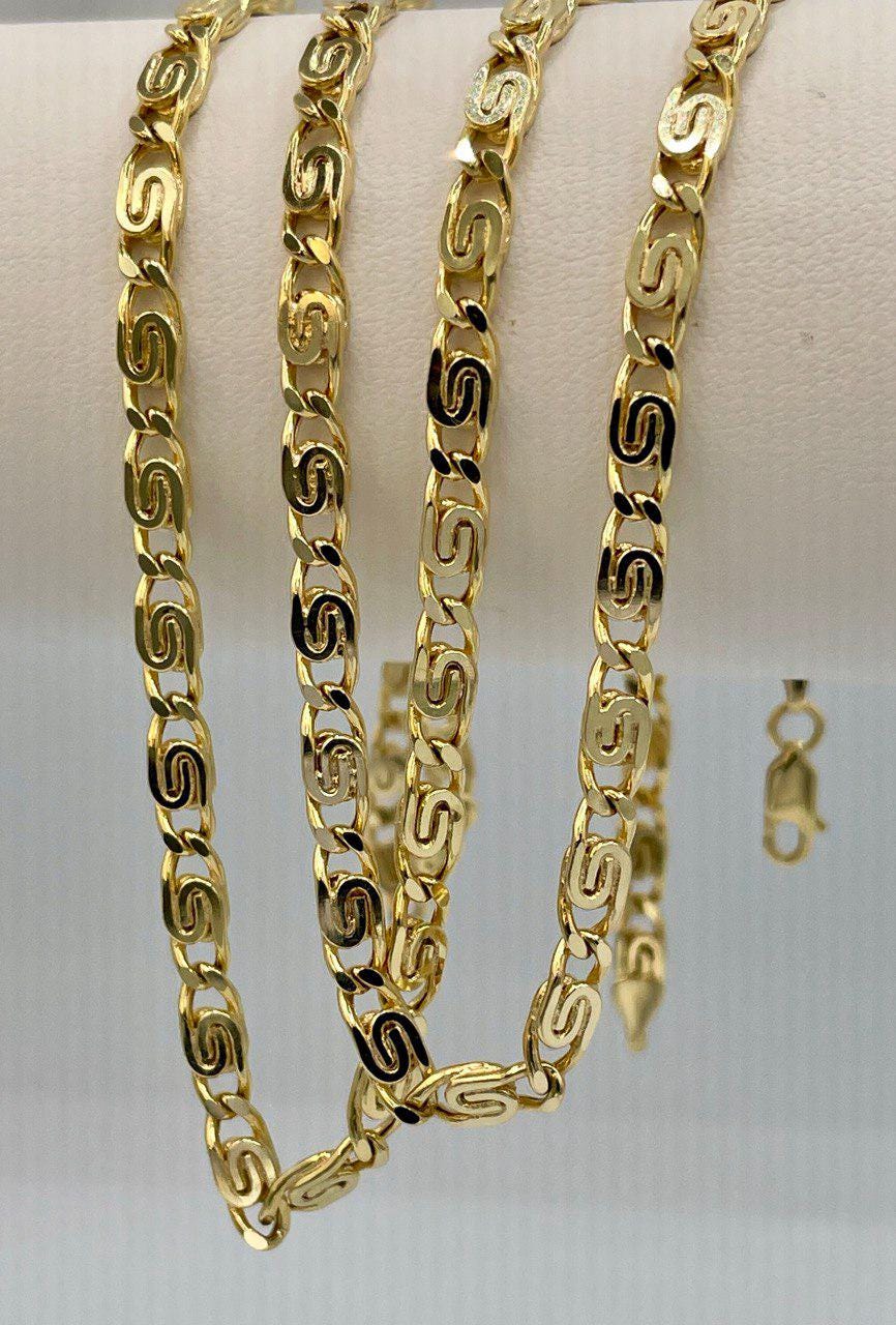 Gold chain necklace on a white surface