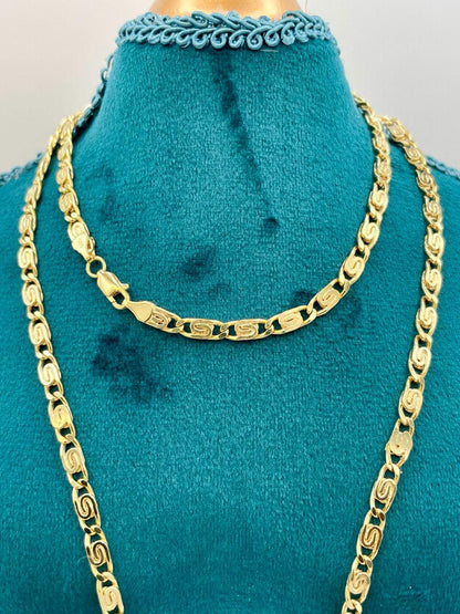 Gold chain necklace on a turquoise mannequin bust