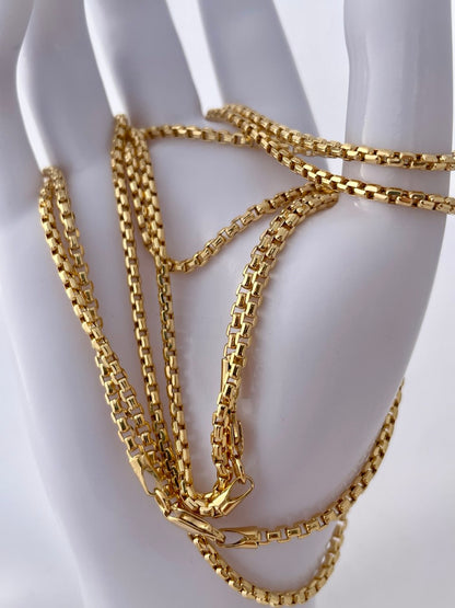 Gold chain necklace on a white mannequin